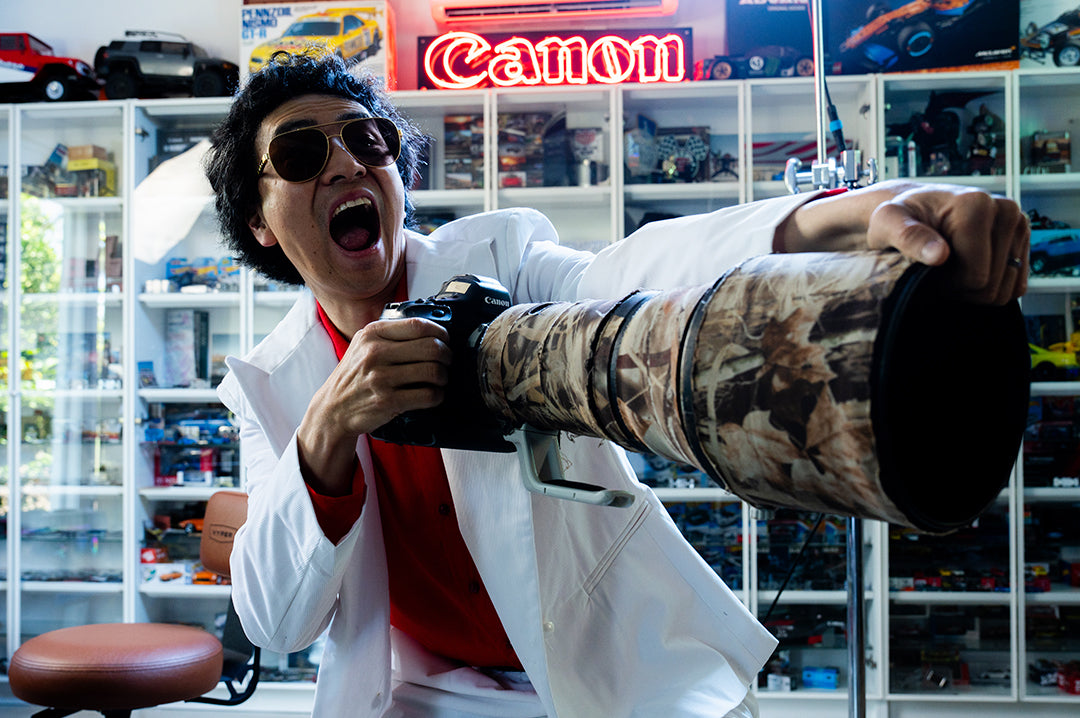 Man holding a camera wearing the Incline Sunglasses: Tortoise Brown Lens