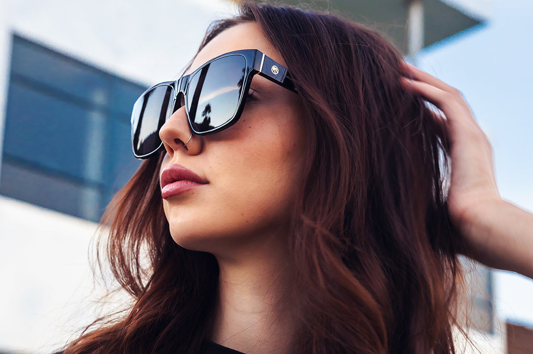 Young women outside wearing the Heat Wave Visual Marylin Sunglasses with black frame and ultra black lenses.