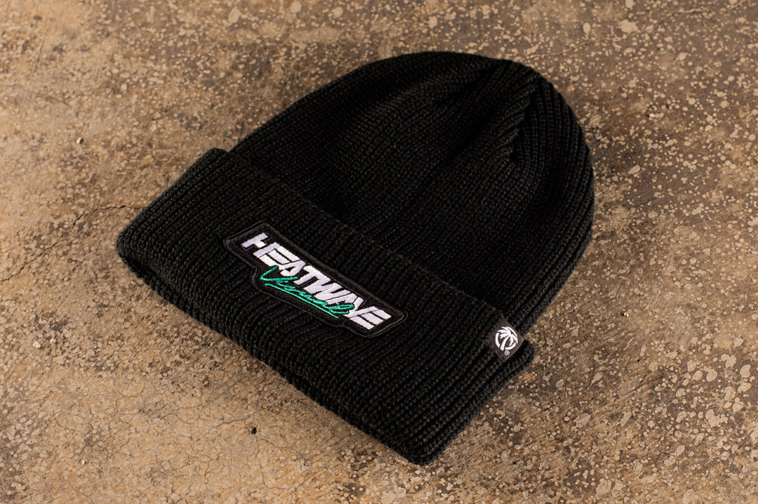 Lying on the ground is the Heat Wave Visual Script Black Beanie.