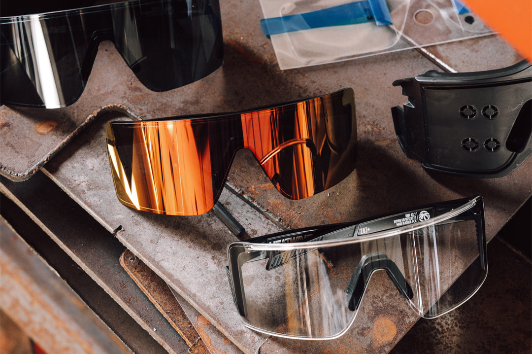 Three Skynet glasses with the jig and Skynet Replacement LPF Lens Protection Film sitting on top of wood