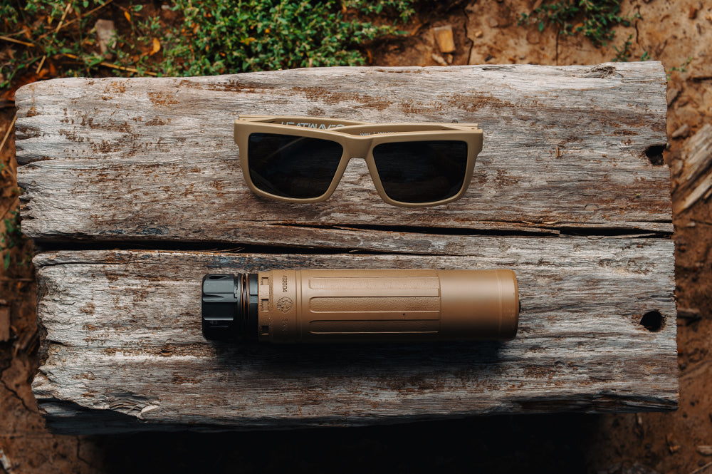 The VISE Z87 Sunglasses DESERT TAN: Black Lens on a wooden log