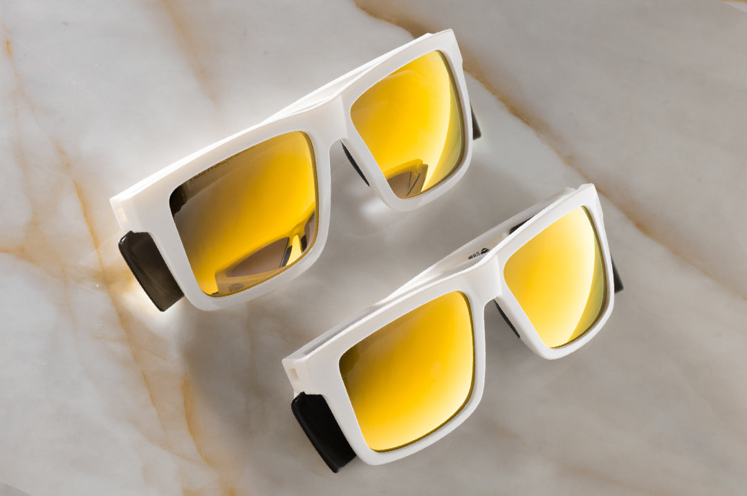 Two pairs of the Performance Vise Sunglasses: GLOSS WHITE Gold Lens Z87+ on a counter