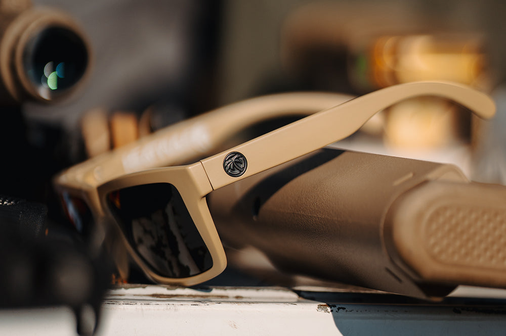 3/4 angle of the XL VISE Z87 Sunglasses DESERT TAN: Black on a table with accessories