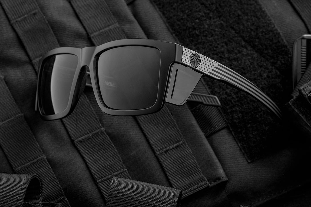 Heat Wave Performance XL Vise black safety glasses with Socom USA Flag arms with bullet proof vest behind them.