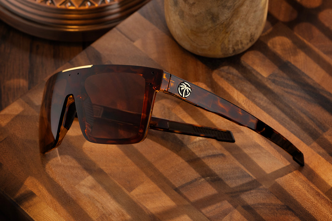 Close up of the Heat Wave Z87+ Performance Quatro Tortoise sunglasses on wooden table shown with side shields removed.