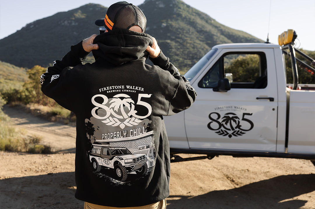Man wearing the Heat Wave x 805 Properly Chill Hoodie - Black showing the backside