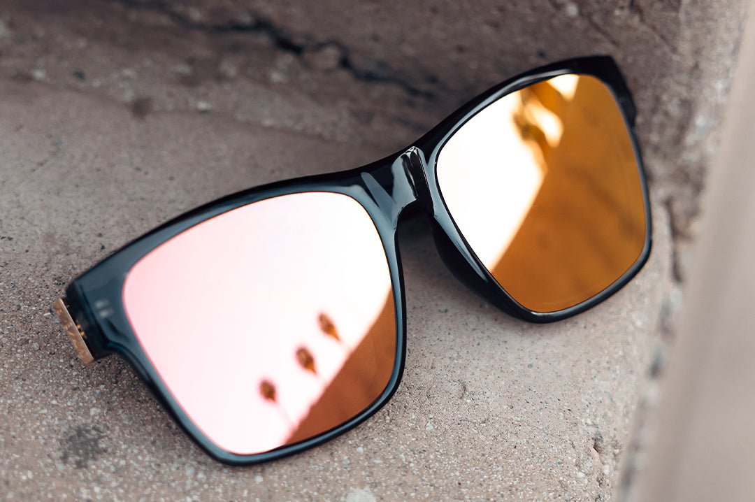 Lying on concrete is the Heat Wave Visual Marylin Sunglasses with quartz frames and rose gold lenses.
