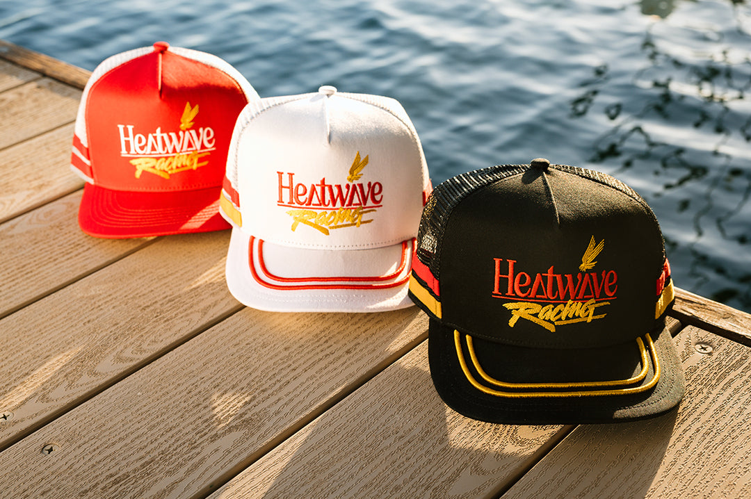 Three colorways of the Offshore hat on a deck by the lake
