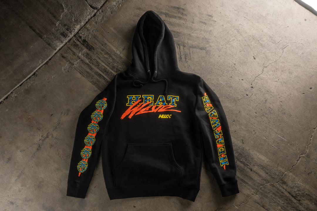 Heat Wave Visual Black Magic Sweatshirt lying on the concrete ground. 