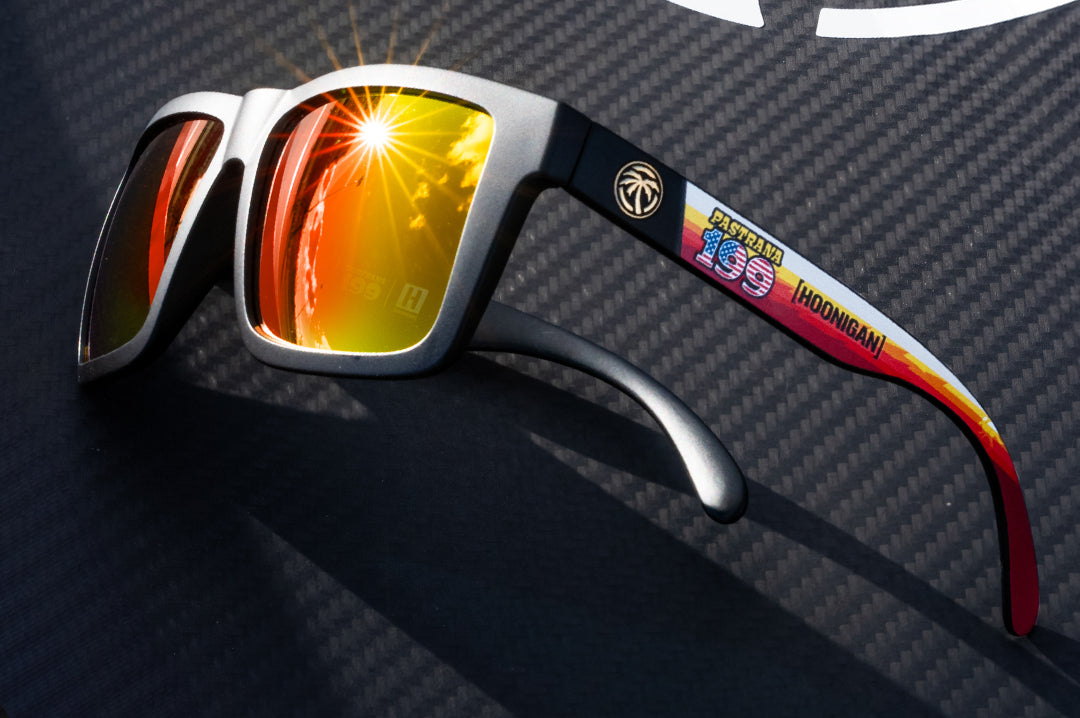 Lying on carbon fiber is the Heat Wave Visual Vise Hoonigan Pastrana Sunglasss. 