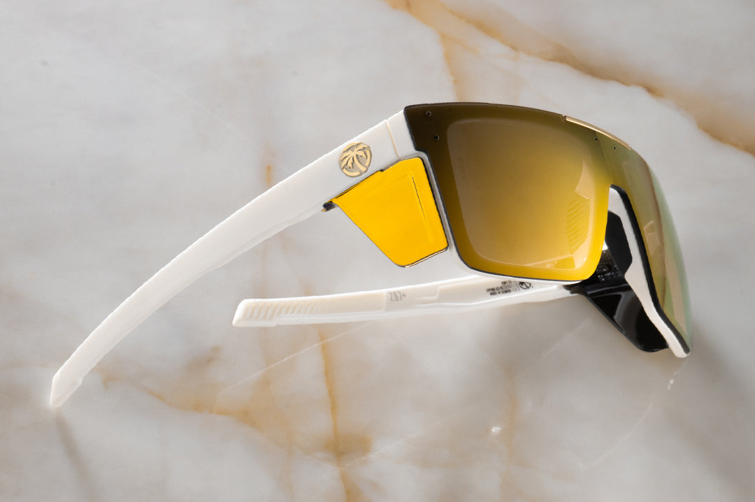 Side profile shot of the Performance Quatro Sunglasses: GLOSS WHITE Gold Lens Z87+ on a counter