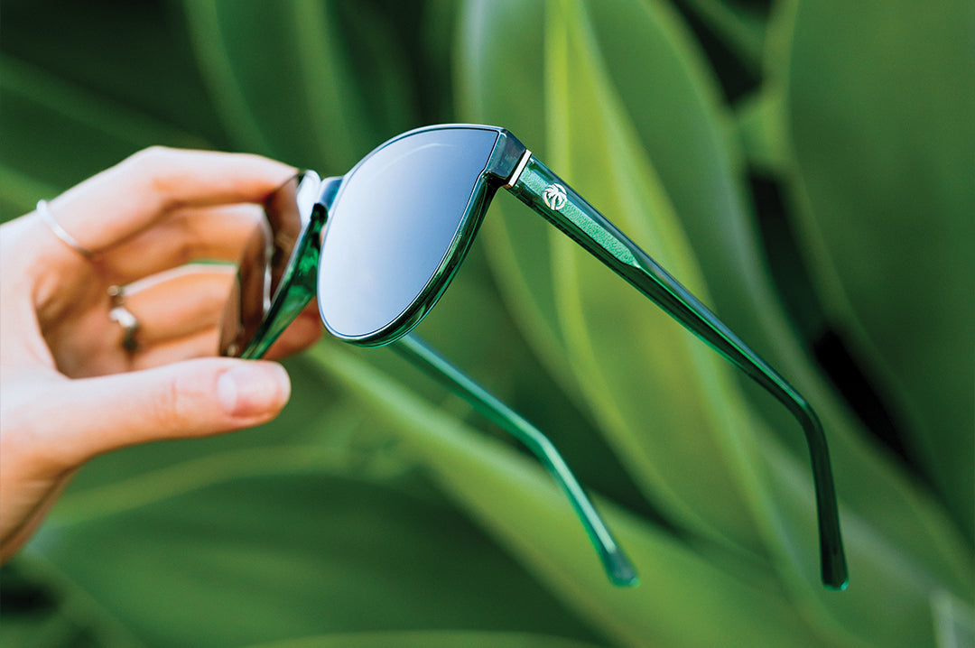 Hand holding the Carat Sunglasses: Cycad Green