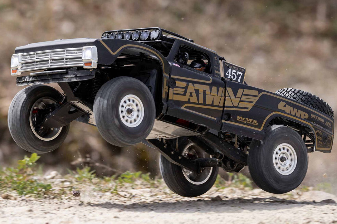 Action shot of the Heat Wave Visual X Losi Baja Rey 2.0 Chris Isenhouer remoted controlled truck jumping. 